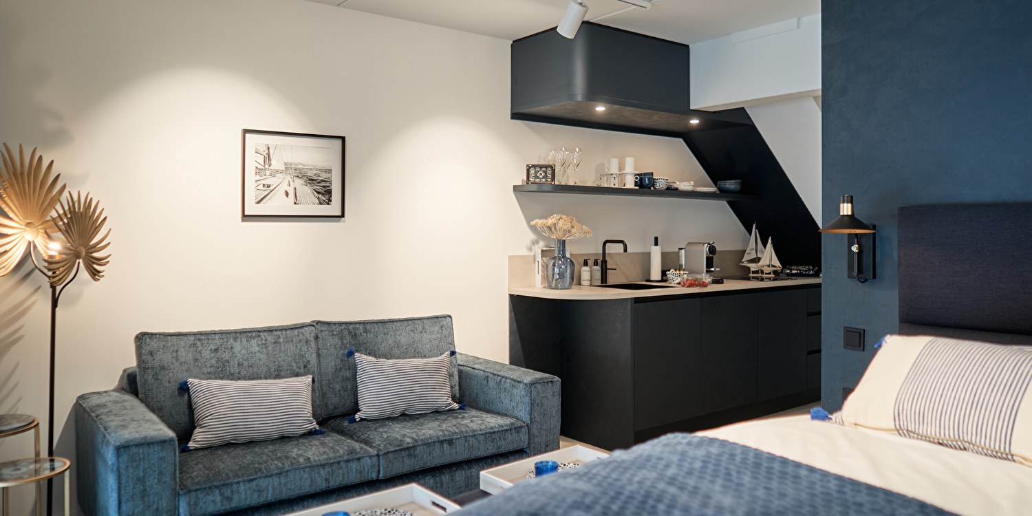 Bed, kitchenette en zithoek van de Captains Boathouse Studio