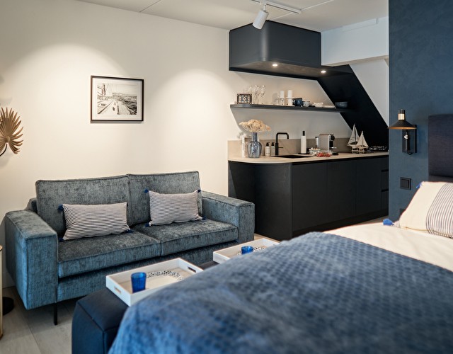 Bed, kitchenette en zitbank van de studio